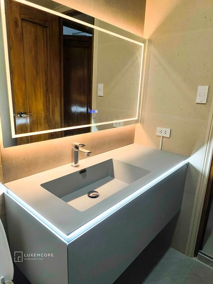 Toilet and bath vanity with illuminated mirror and integrated sink